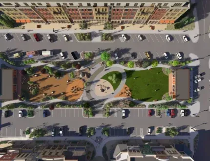 Aerial view of a landscaped urban park surrounded by parking lots and buildings.
