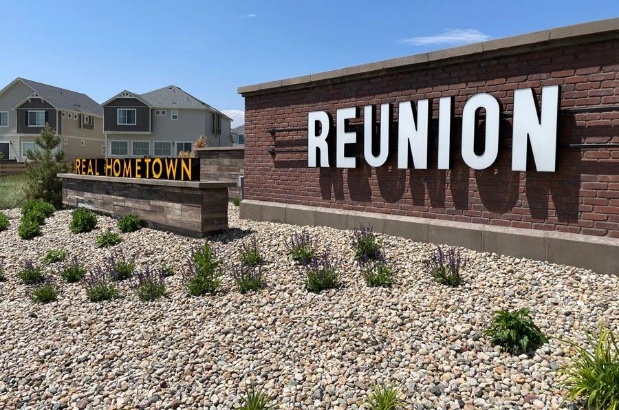 Brick and wood entrance sign for Reunion community in Commerce City, CO.