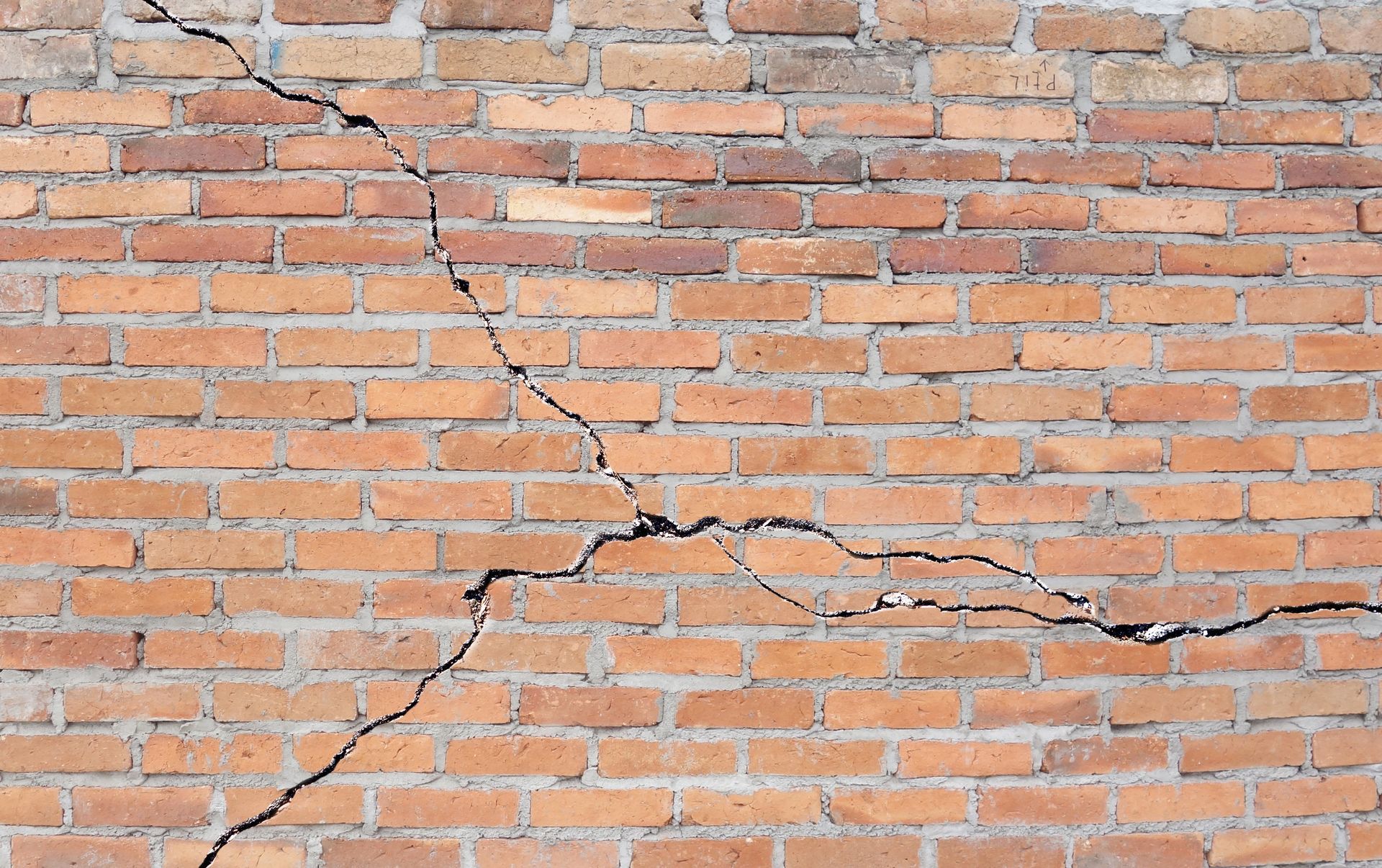 Brick wall with a significant diagonal crack.