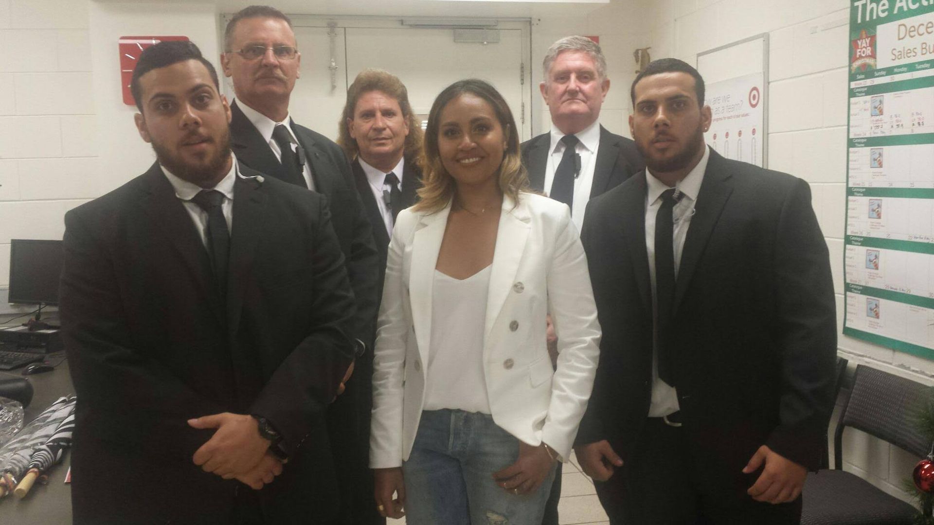 A Man In A Suit Is Standing In Front Of A Crowd Of People - Event Security in Darwin, NT