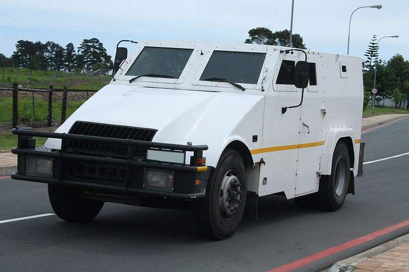 A White Armored Vehicle Is Driving Down A Road - Secure Cash in Transit in Darwin, NT
