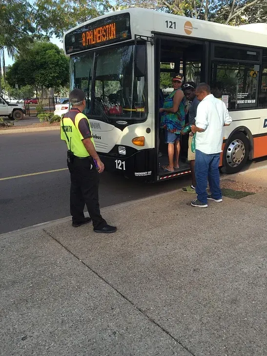 A Security Guard Monitoring People Hoping On A Bus - Comprehensive Security Services in Darwin, NT