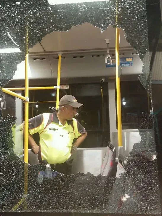 A Security Guard Behind A Brocken Window Of A Bus - Risk Management & Risk Assessment in Darwin, NT