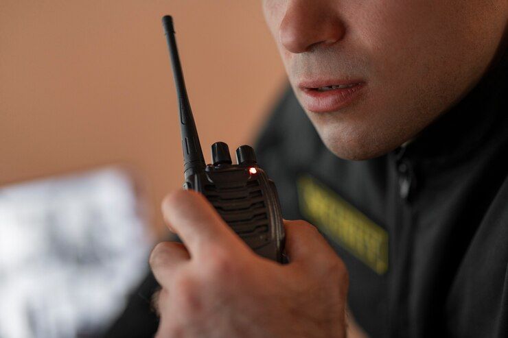A Man Is Holding A Walkie Talkie In His Hand - Professional Security in Darwin, NT