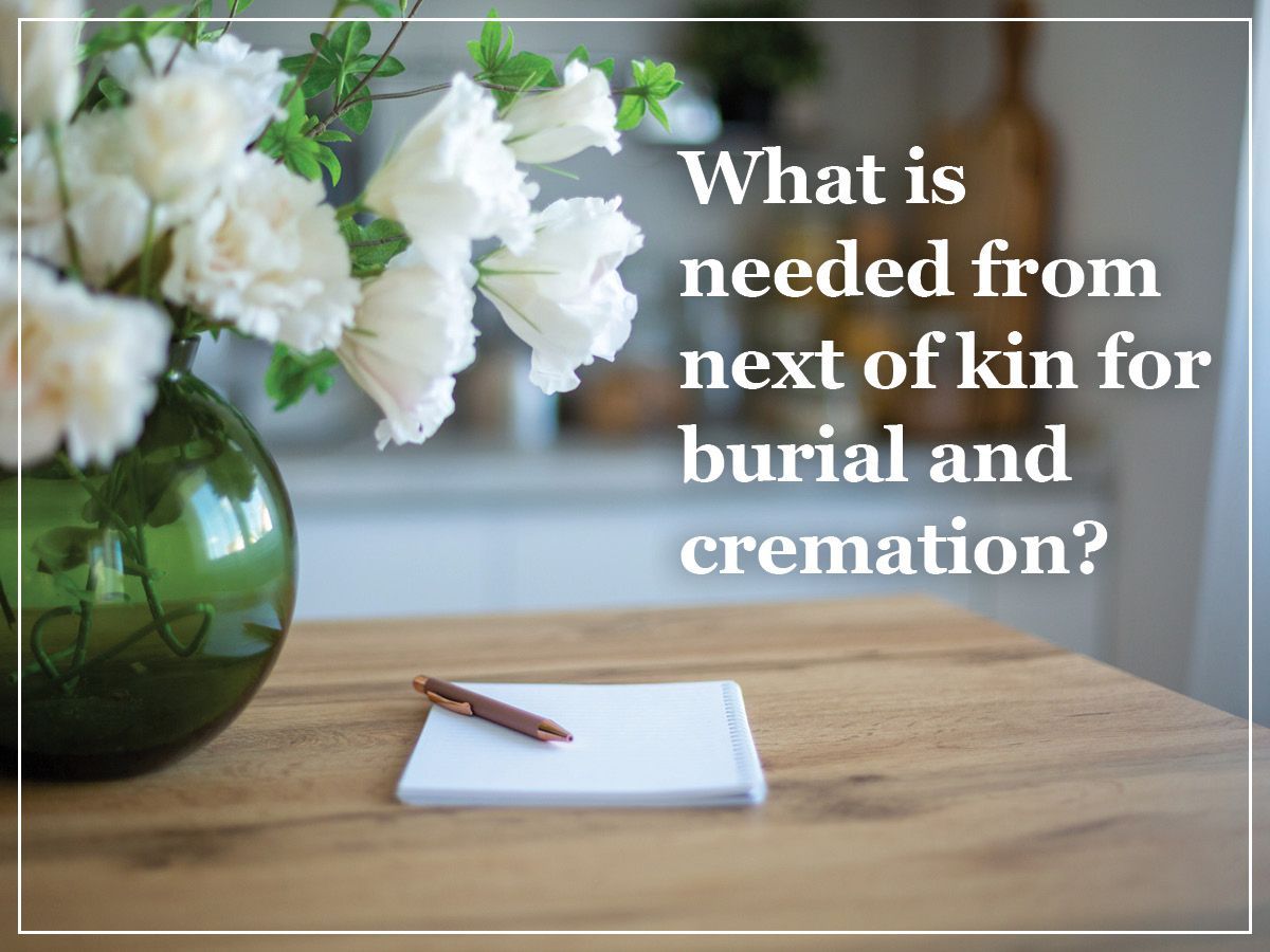White flowers in vase beside note and pen; text asks what next of kin need for burial cremation