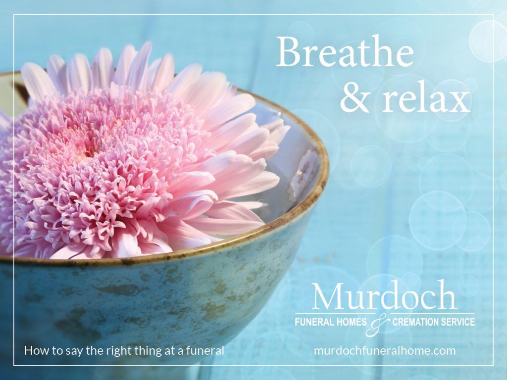A pink flower in a bowl that says breathe and relax