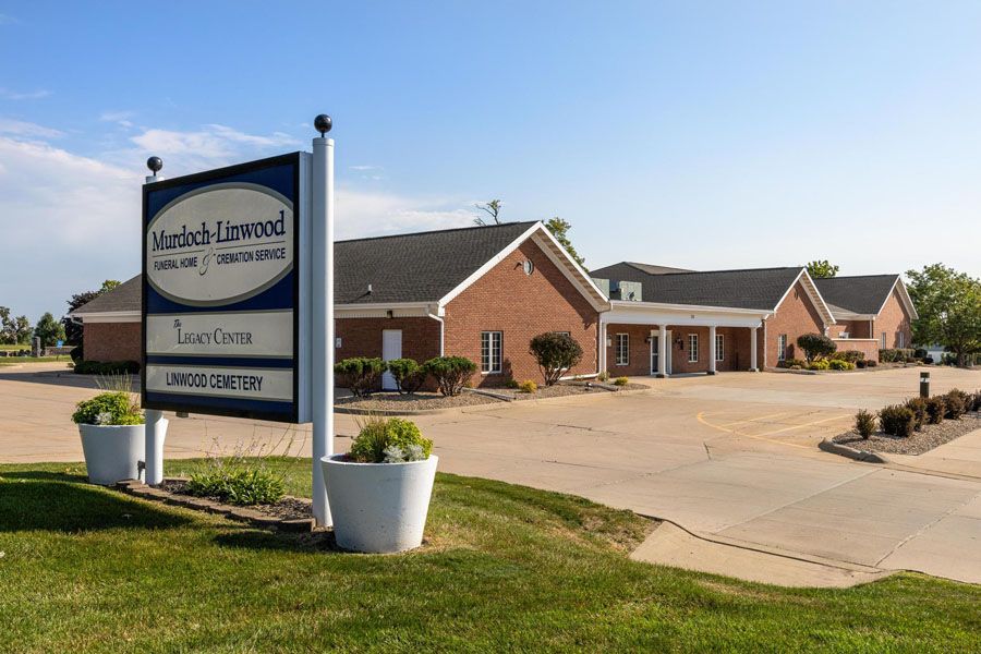Brick church and sign by a paved parking lot on a sunny day