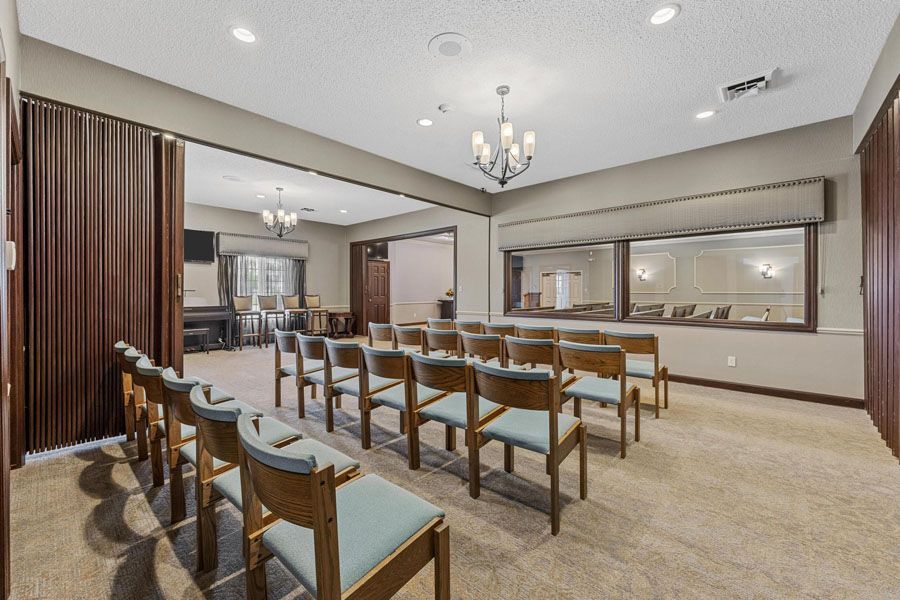 Conference room with rows of chairs facing a presentation area and large interior windows