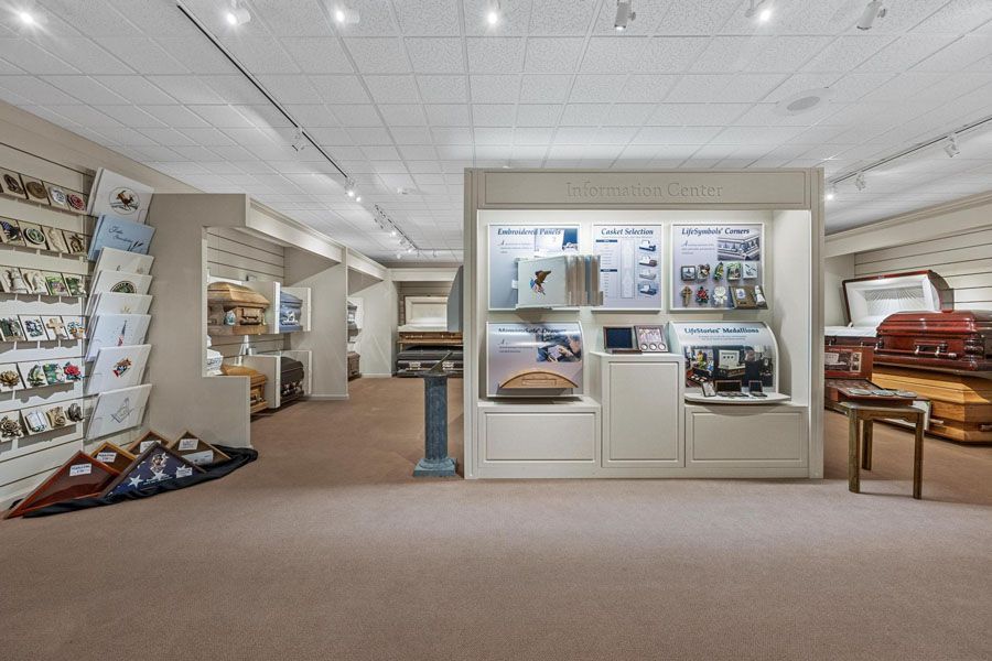 Bright museum exhibit hall with display cases, wall panels, and a sofa under white ceiling lights