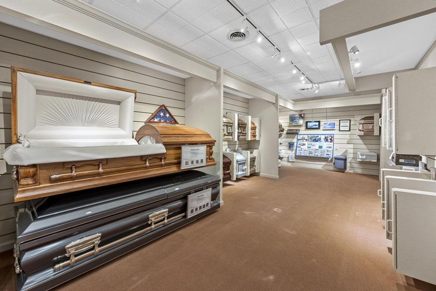 Furniture store showroom with beds, lamps, and display cabinets under bright ceiling lights