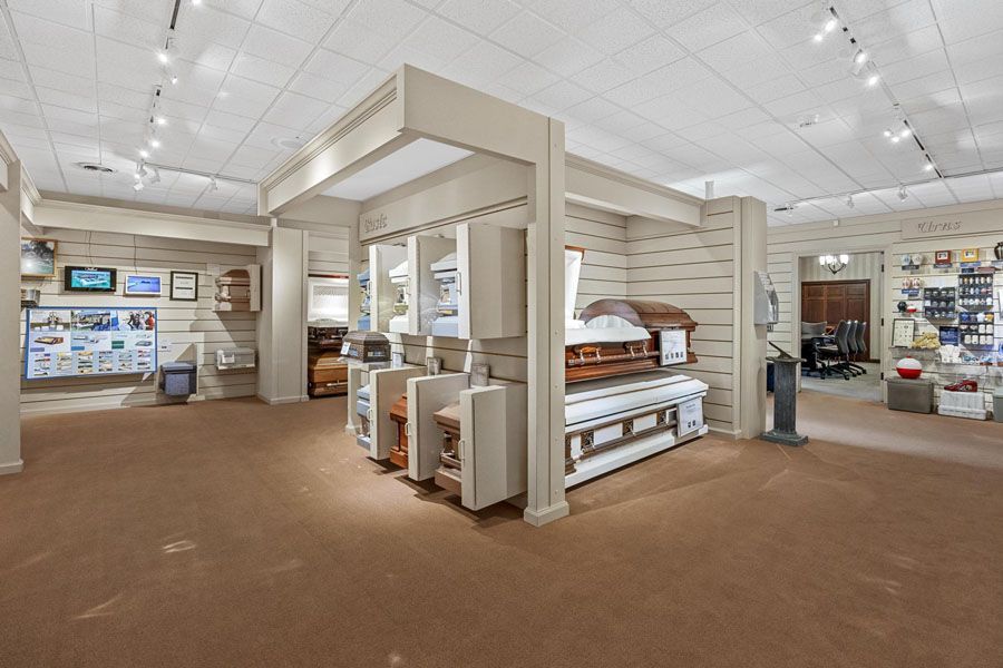 Bright furniture showroom with shelves, display beds, and brown carpet under white ceiling lights