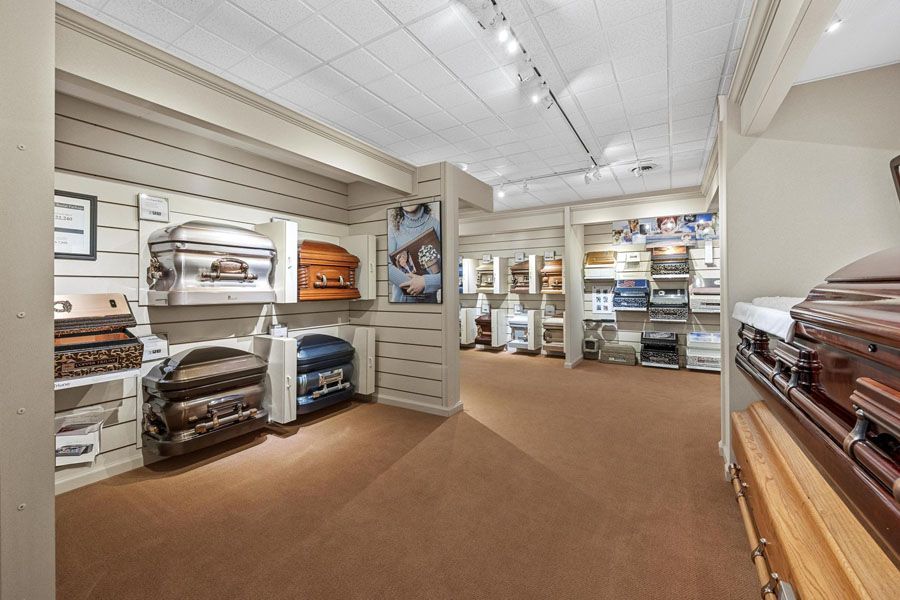 Carpeted store showroom with shelves of folded rugs and home decor in a bright aisle