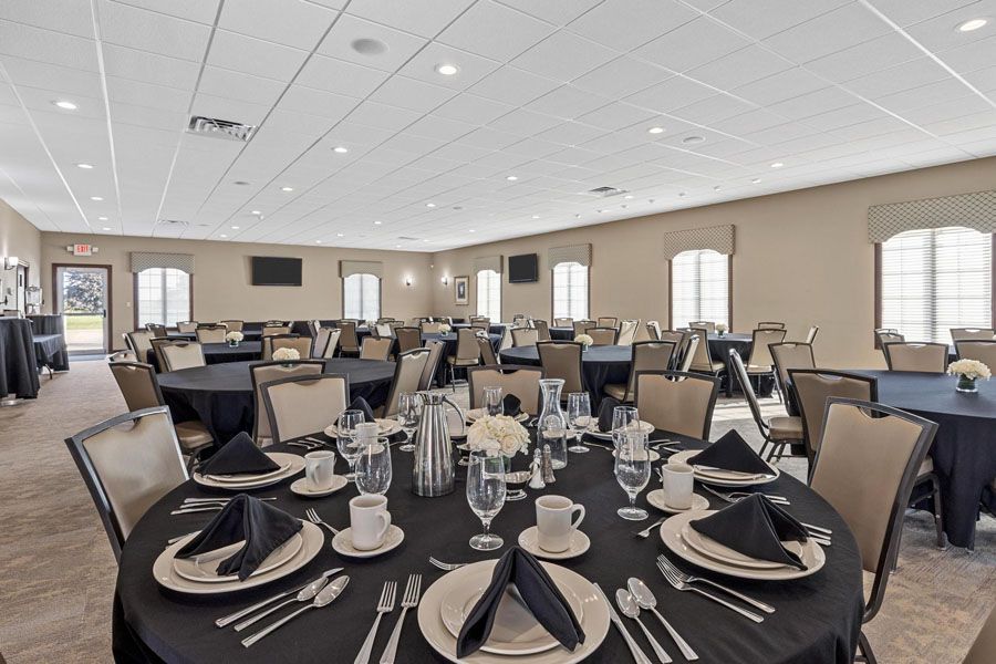 Set banquet table in a bright conference hall with black napkins and white china