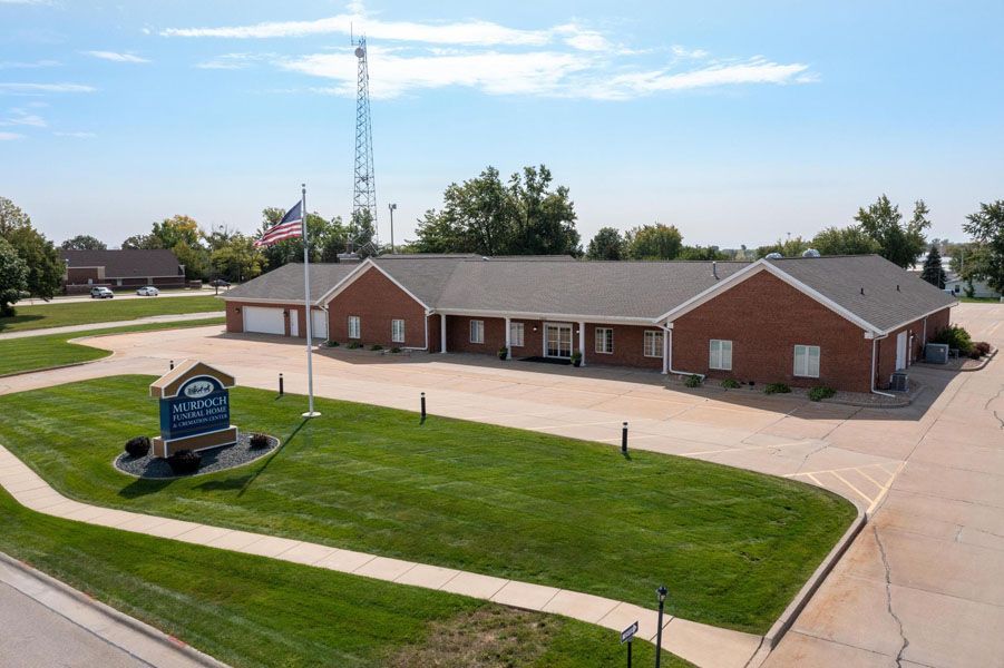 Brick community building with flagpole and sign, seen from above on a sunny day