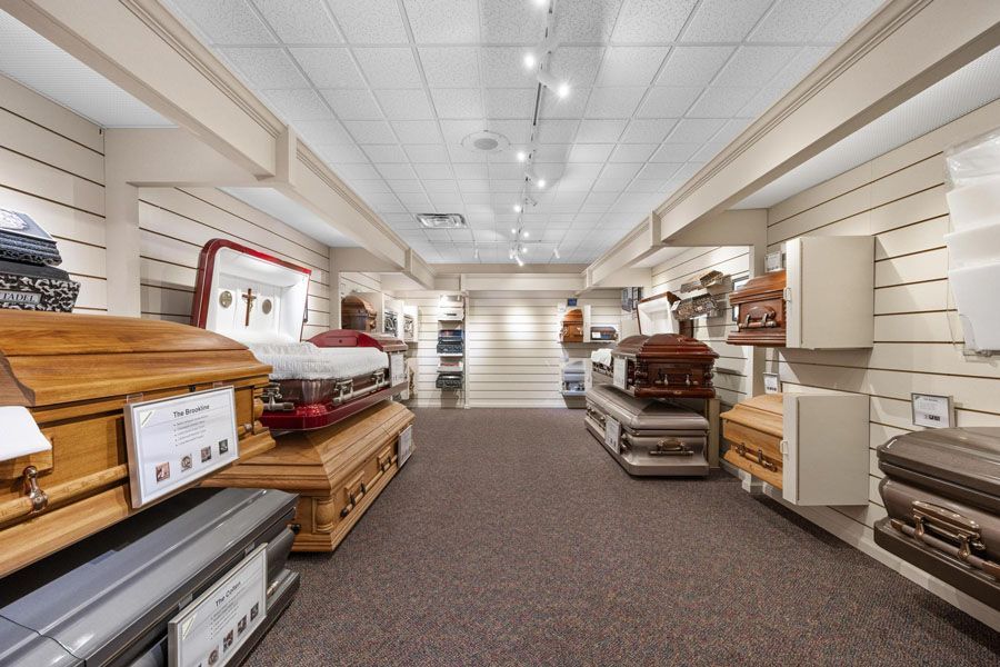 Mattress showroom aisle with stacked beds, shelves, and bright ceiling lights