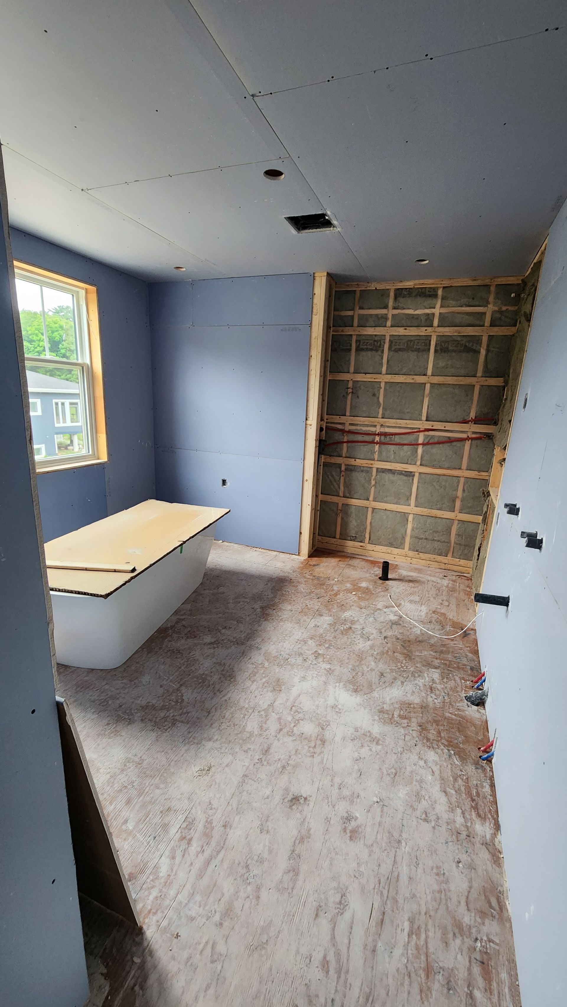 Une chambre en construction avec une baignoire et une fenêtre.