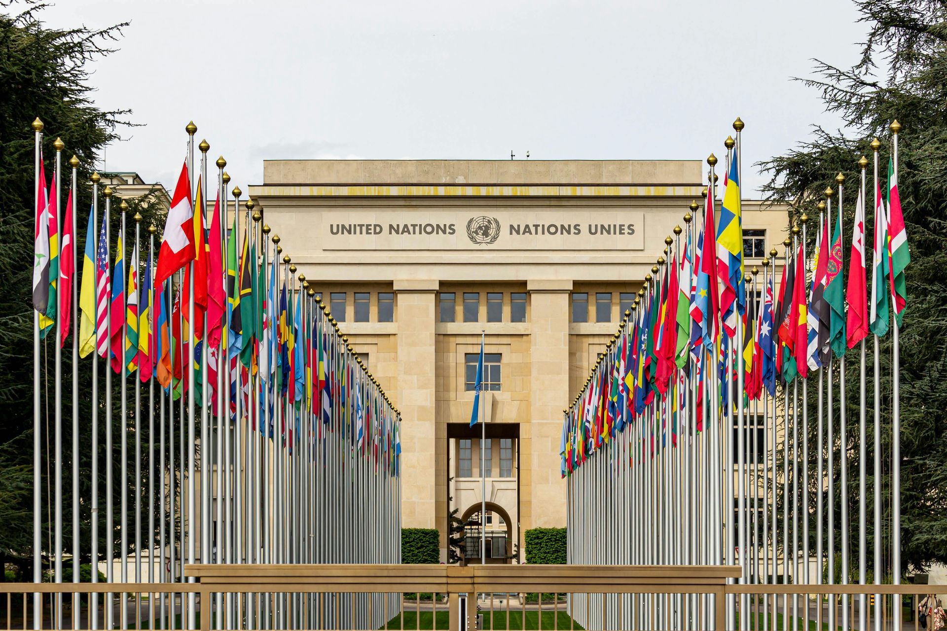 Entrance of the United Nations building with UN member country flags. Links to services page 