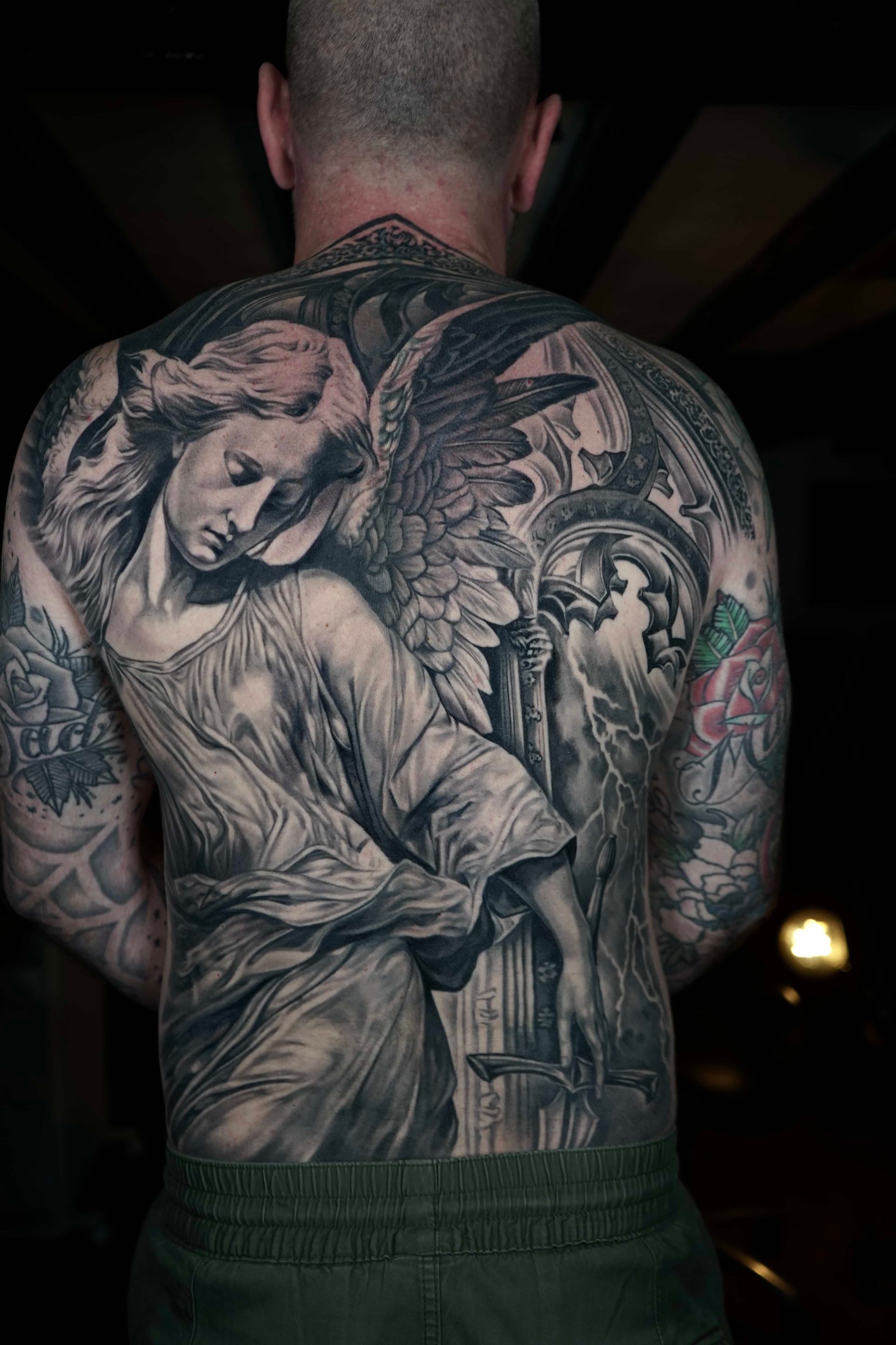 A realistic tattoo of a character with ginger hair, weathered skin, and an intense gaze, rendered in warm, fiery tones.