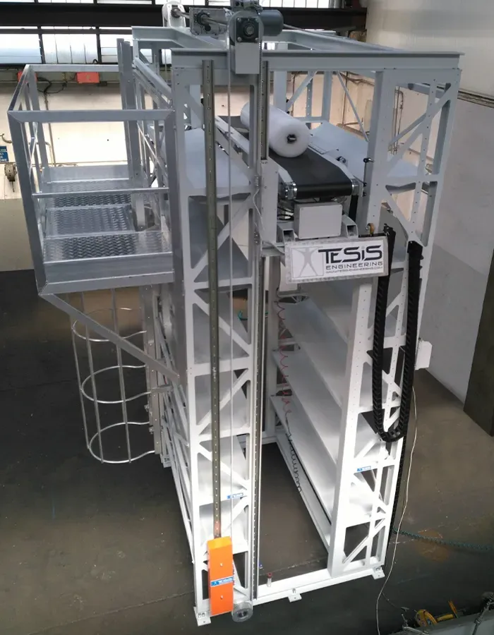 Magazzino automatico di accumulo verticale rotoli tessuto con navetta di sollevamento centrale