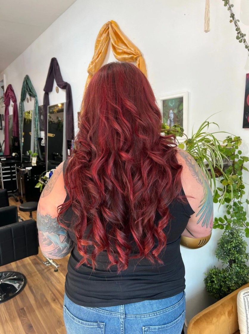 Person with long, wavy, red hair in a hair salon.
