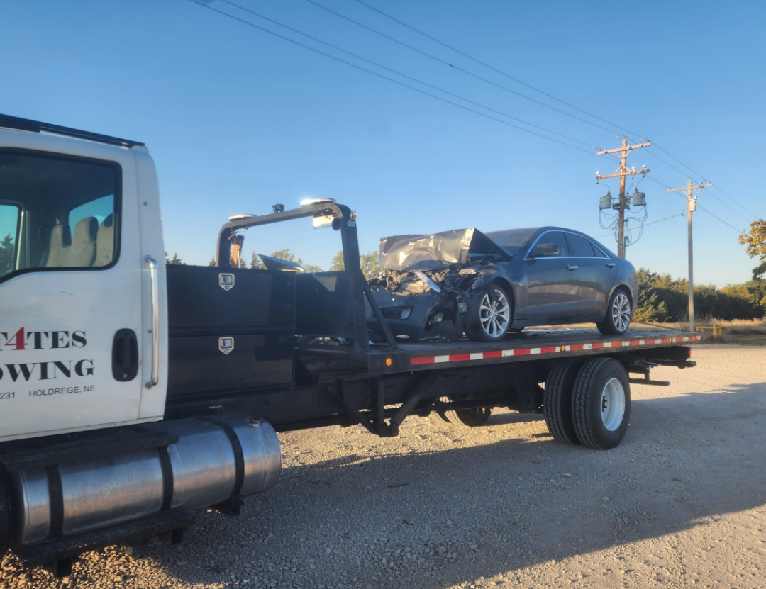 A tow truck with a car on the back of it