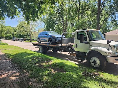 A tow truck is carrying a car on the back of it.