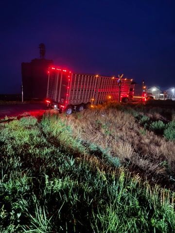 Two semi trucks are parked on the side of the road.
