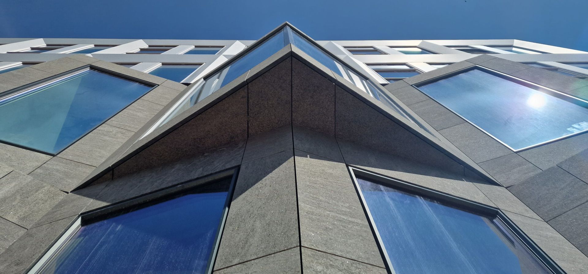 Omhoog kijkend naar een gebouw met een blauwe lucht op de achtergrond