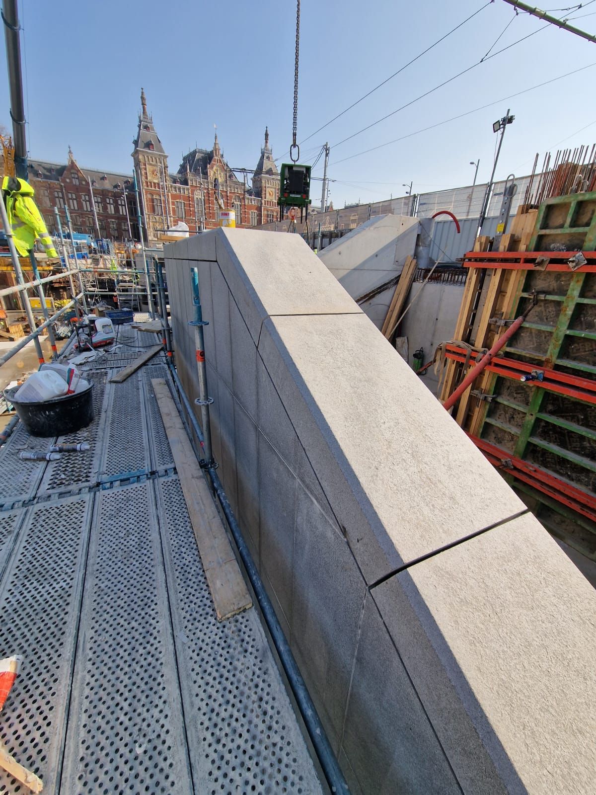 Een groot betonblok wordt door een kraan opgetild