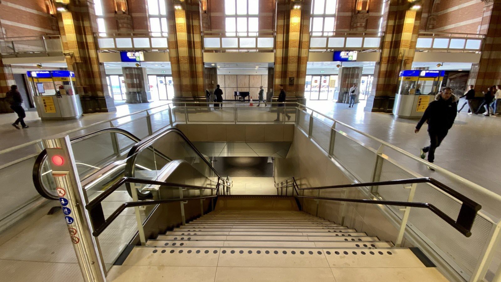 Een persoon loopt een trap af in een treinstation.