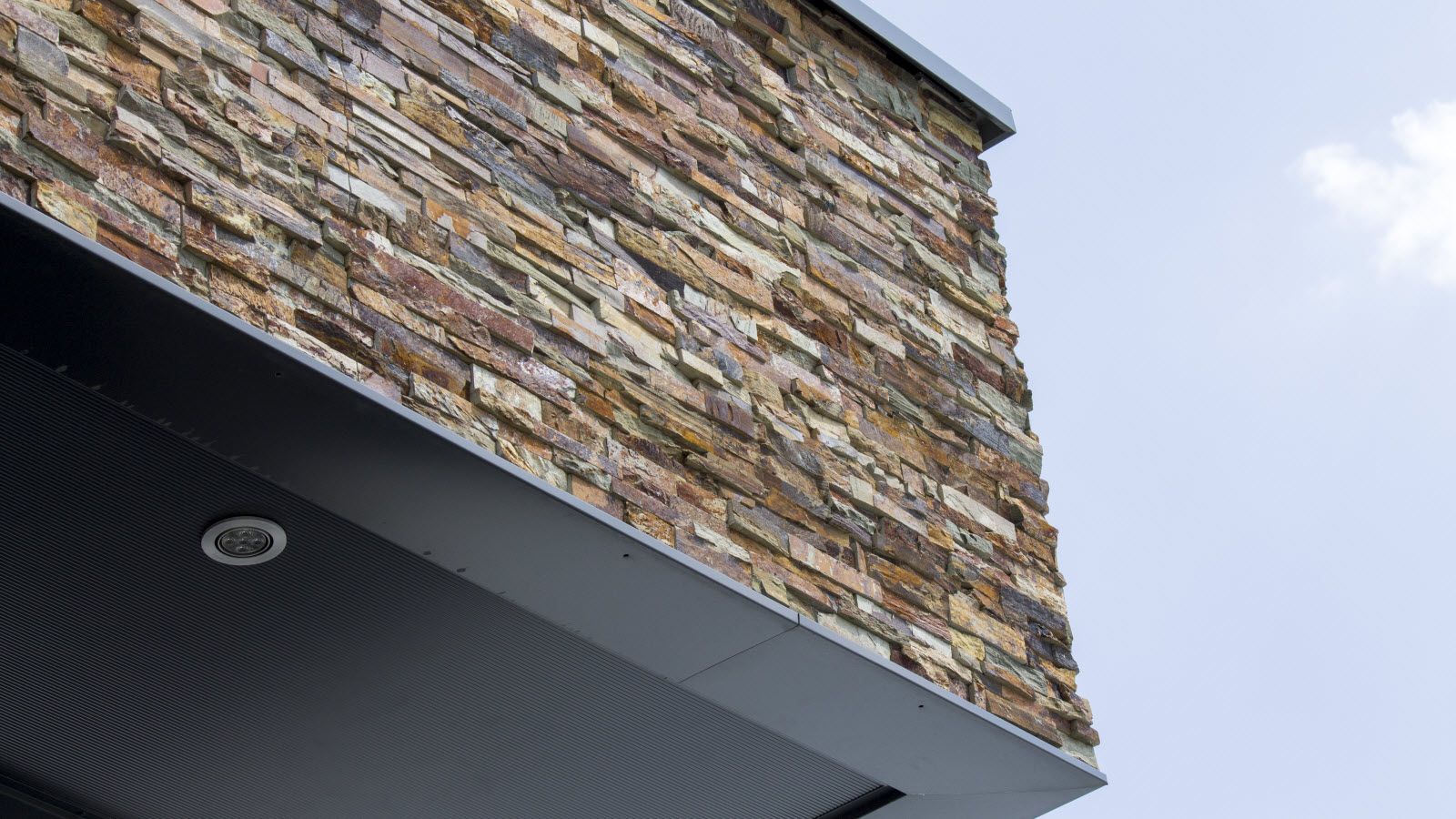 Een close-up van een stenen muur op een gebouw met een blauwe lucht op de achtergrond.