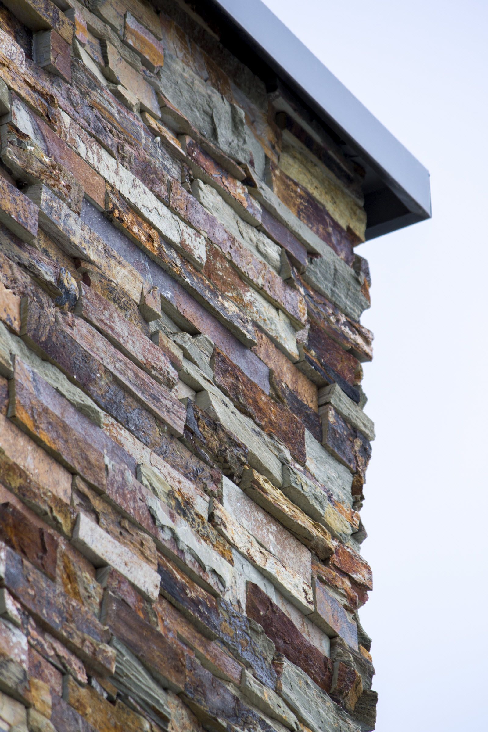 Een close-up van een stenen muur met een metalen dak.