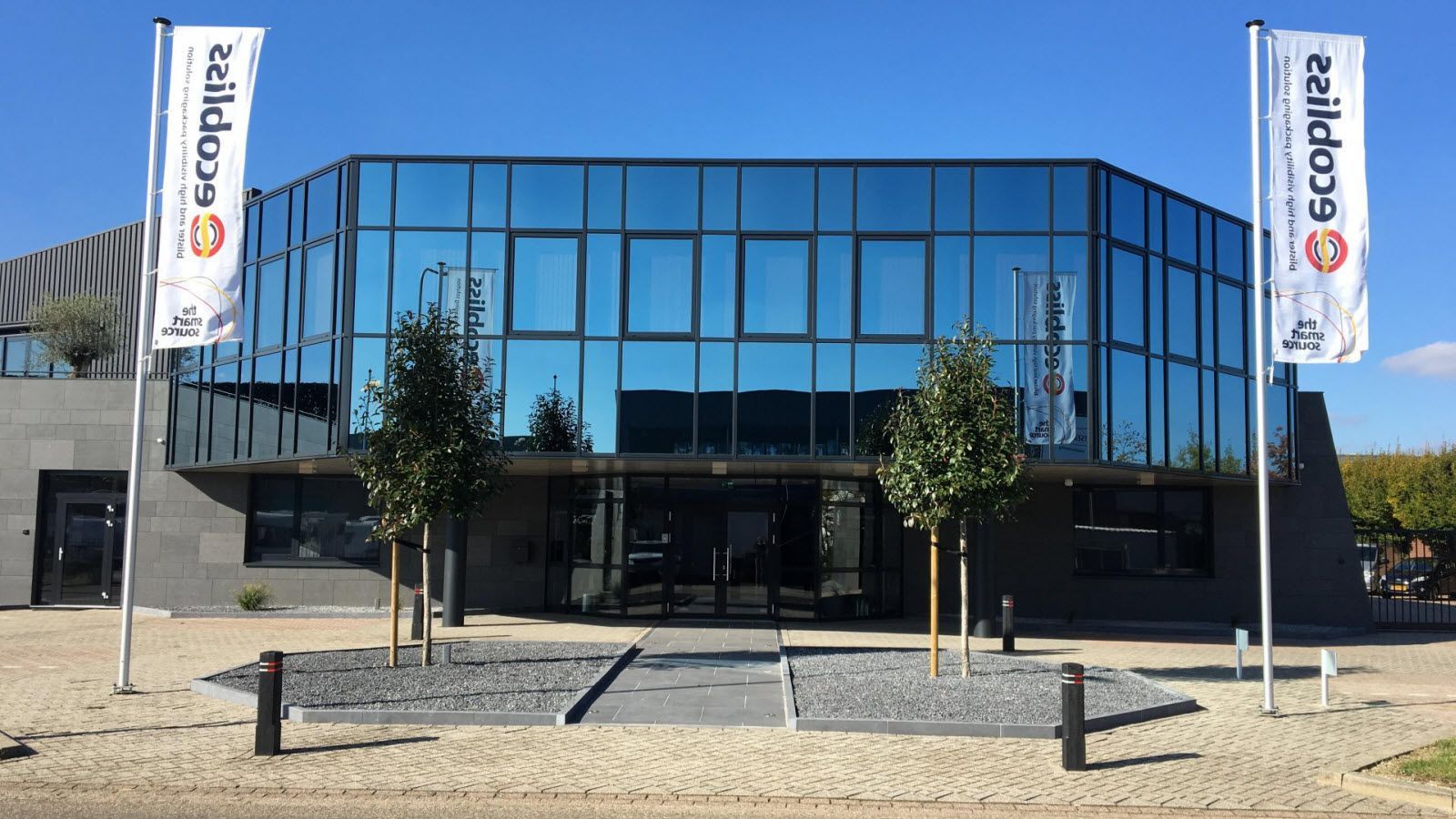 Een groot gebouw met veel ramen en vlaggen ervoor.
