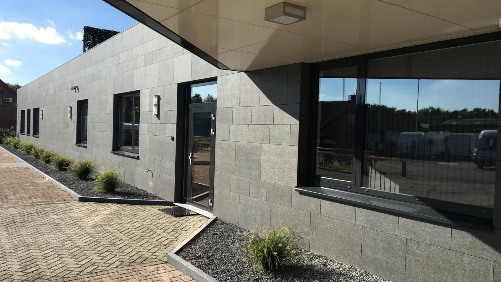 Een gebouw met veel ramen en planten ervoor