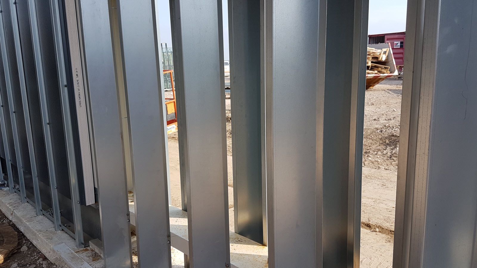 Een close-up van een metalen hek op een bouwplaats.