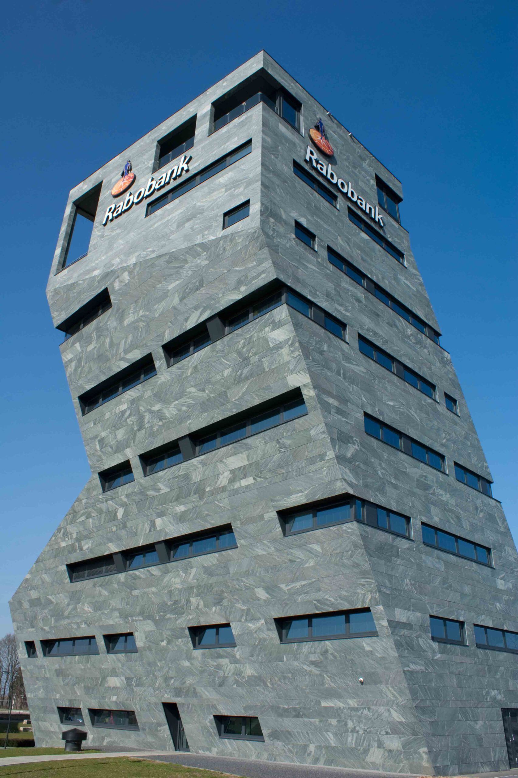 Een hoog gebouw met een blauwe lucht op de achtergrond.