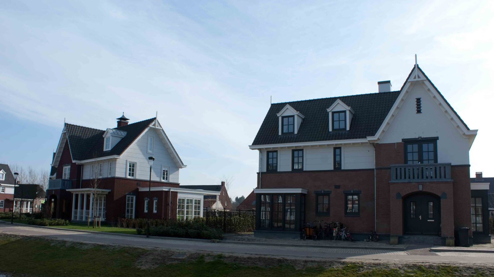 Twee huizen met zwarte daken staan ​​naast elkaar