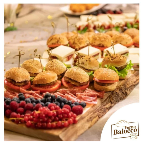 Un vassoio di legno colmo di mini hamburger, tramezzini, affettati e frutti di bosco freschi, con il marchio Forno Baiocco.