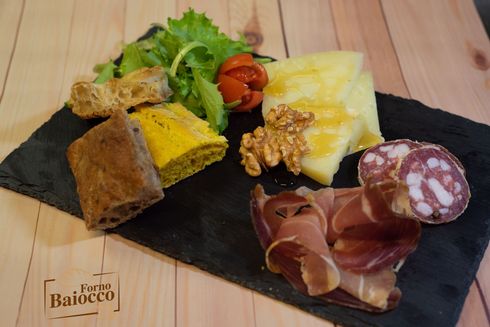 Un tagliere di salumi con affettati, formaggi con miele e noci