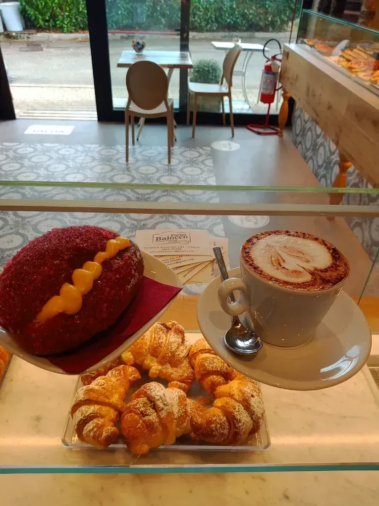 Una vetrina che espone un pasticcino glassato di rosso con crema pasticcera