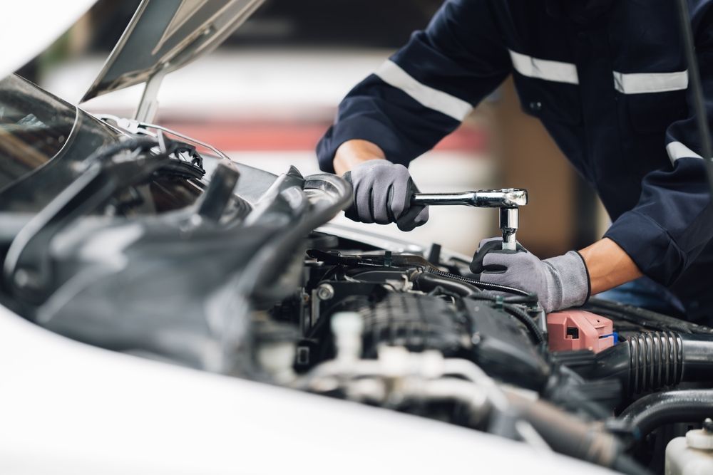 A man is working on the engine of a car.