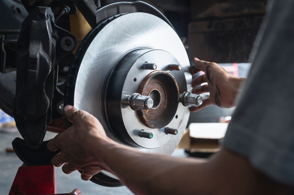 A man is fixing a brake disc on a car.