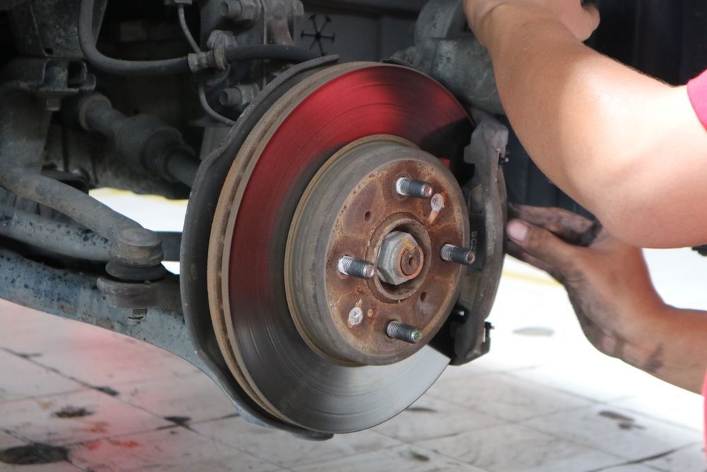 A person is fixing a brake disc on a car.