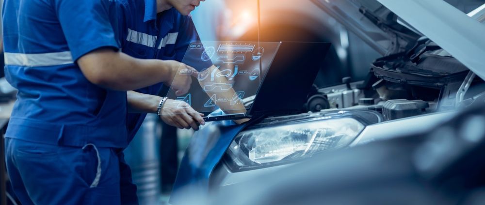 Two mechanics are working on a car in a garage.