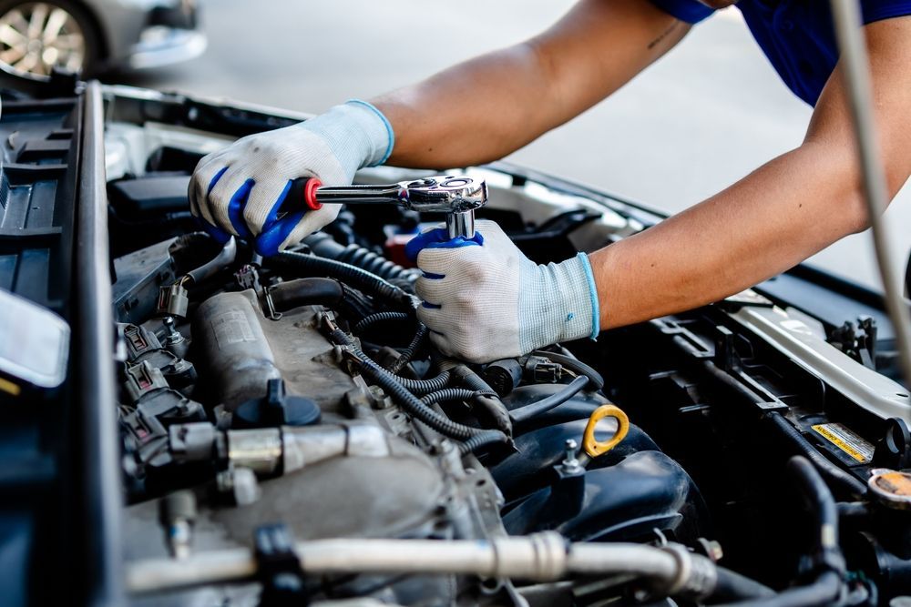 A man is working on the engine of a car.