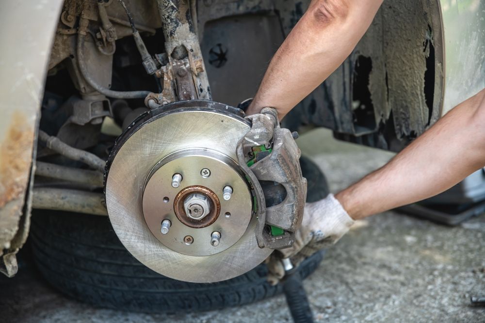 A person is fixing a brake disc on a car.