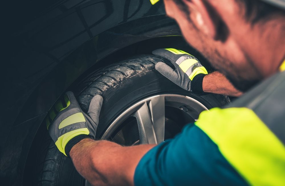 A man is changing a tire on a car.