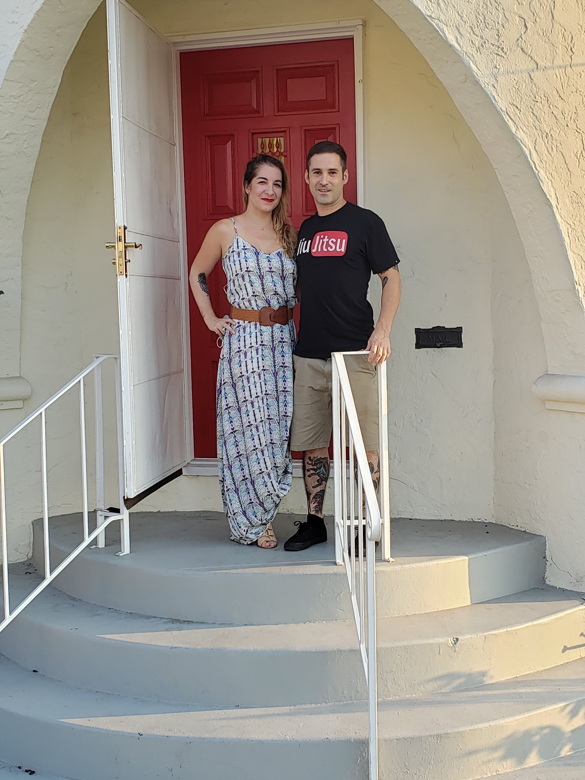 Clients of Eloise Real Estate Group are standing in front of a red door.