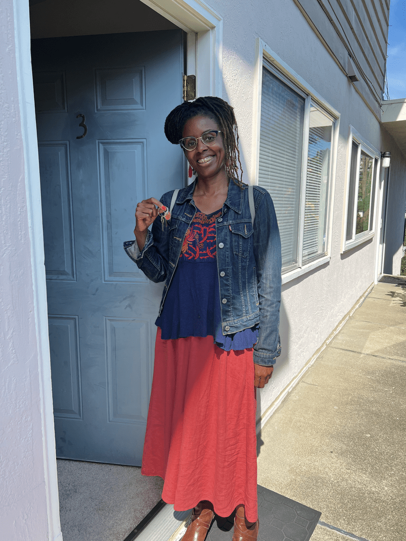 A client of Eloise Real Estate Group is standing in front of a door holding a key.
