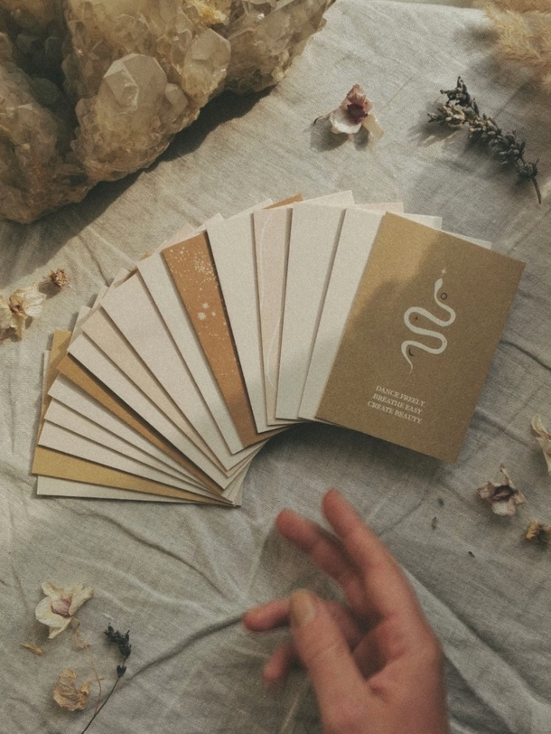Minimalistische, beige en bruine affirmatie kaarten met hand gewaaierde, gedroogde bloemen op een zachte stoffen achtergrond.